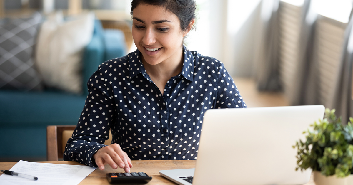 woman working with a laptop and a calculator